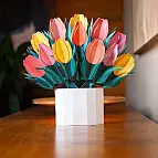 Ein weißer Umschlag zum Aufbewahren des gefalteten Straußes und ein Kärtchen zum Schreiben einer Nachricht liegen bei.